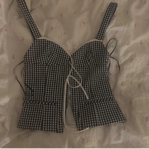 Svartvit rutig korsett - Snygg svartvit rutig korsett med breda axelband och snörning framtill. Strl S 💓💓