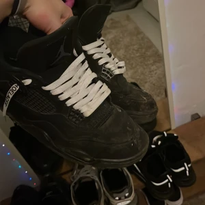 Jordan 4 Blackcats med off-white snören - Säljer ett par Jordan 4 eftersom har inte så mycket att styla med o är lite för små för mig tvättar så klart av dem om jag säljer dom. Liten repa på baksidan av moped olycka men annars är dem i bra skick