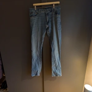Blå jeans från Polo Ralph Lauren - Snygga blå jeans från Polo Ralph Lauren. Klassisk design med fem fickor och knappgylf. Perfekta för en avslappnad stil.
