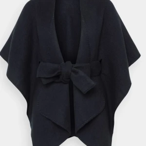 Svart omlottjacka med knyt - Elegant svart jacka med ett stilrent knytband i midjan. Jackan har en unik design med vida ärmar och en mjuk, bekväm passform. Perfekt för att ge en extra touch till din outfit!!!