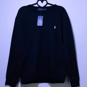 Ralph Lauren Sweatshirt - Helt ny Ralph Lauren sweatshirt med det klassiska logotypbroderiet på bröstet. Tröjan har långa ärmar och en rund halsringning, perfekt för en stilren look. Finns fler storlekar i min profil, kom gärna med frågor och bud!😁