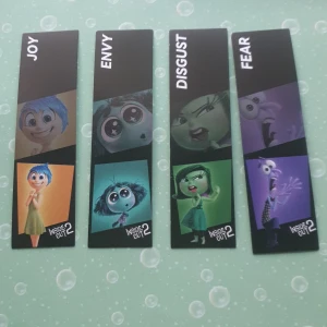 Bokmärken från Inside Out 2 - Säljer ett set med fyra bokmärken från filmen Inside Out 2. Bokmärkena har karaktärerna Joy, Envy, Disgust och Fear i färgglada illustrationer. Perfekt för fans av filmen som vill ha något unikt till sina böcker.