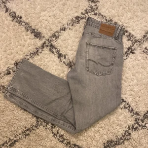 Grå jeans från Jack & Jones - Snygga grå jeans från Jack & Jones i modellen Relaxed/Chris. Är lite slitna( se bild 3) men annars väldigt fint skick. Nypris 599