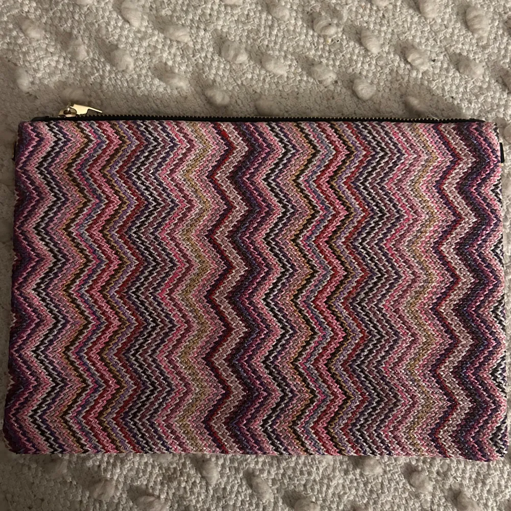 Säljer en super söt somrig kuvertväska med ett färgglatt zigzag-mönster i rosa, lila och andra nyanser. Väskan har en dragkedja upptill och är perfekt för att ge din outfit en färgklick😻. Laukut & Käsilaukut.