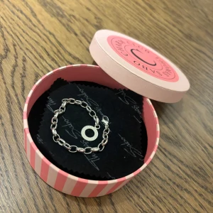 Silverarmband från Thomas Sabo Charm Club - Elegant silverarmband från Thomas Sabo Charm Club. Armbandet har en rund berlock med text och är perfekt för att fästa fler charms. Levereras i en snygg rosa och vit randig ask. Armbandet är helt i nyskick då jag fick det i julklapp och det tyvärr var för litet 🌸😔