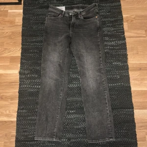 Svarta jeans från H&M - Snygga svarta jeans från H&M i straight regular fit. Klassisk design med fem fickor och knappgylf. Perfekta för en avslappnad stil. Längd 32