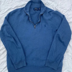 Blå tröja med dragkedja från Polo Ralph Lauren - Snygg blå tröja från Polo Ralph Lauren i mjuk pima bomull. Tröjan har en dragkedja vid halsen och ett diskret broderat märke på bröstet. Perfekt för en stilren look. Snygg för att va lite extra fin på en middag eller vanlig skoldag🍷🍾🍽️🏫🎓