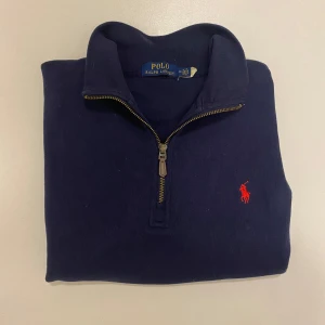 Marinblå Ralph Lauren halv zip -  Polo Ralph Lauren halv zip. Perfekt för en avslappnad och snygg look. Den är är i väldigt bra skick utan hål, fläckar eller liknande, skriv vid minsta fråga eller fundering💯👍
