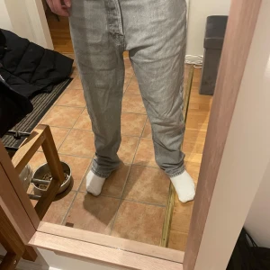 Grå jeans från Jack & Jones - Säljer ett par grå jeans från Jack & Jones, modell Relaxed/Chris. De har en avslappnad passform och är tillverkade i denim. Perfekta för en casual look. Jag på bilden är 160 och dom passar bra. Tecken på användning som ni ser