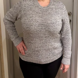 Grå stickad tröja från GANT Rugger - Säljer en stilren grå stickad tröja från GANT Rugger. Perfekt för kyliga dagar med sin mjuka och bekväma passform. Tröjan har långa ärmar och en klassisk rund halsringning.