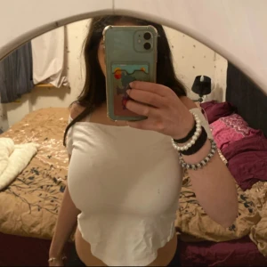 Vit offshoulder topp från Bik Bok - Säljer en stilren vit offshoulder topp från Bik Bok. Toppen är croppad, perfekt för sommarens varma dagar. Den är tillverkad i ett mjukt och bekvämt material.