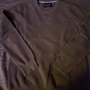 Säljer en snygg mörkgrön stickad tröja från Bondelid. Den har en klassisk design med rund hals och diskret broderad logga på bröstet som jag tycker är väldigt snyggt. Tröjan är i Storlek M 