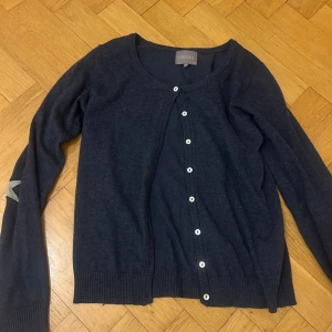 Mörkblå kofta från Culture!!! - Säljer en snygg mörkblå kofta från Culture med stjärndetaljer på armbågarna. Koftan har långa ärmar och knäpps med vita knappar framtill. Säljer eftersom jag inte använder den längre! Super bra skick och verkligen så fin på. Priset kan diskuteras ❤️