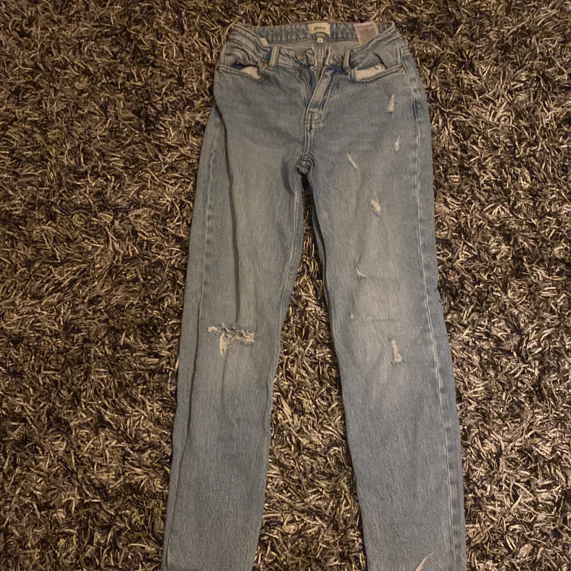 Blå jeans med slitningar