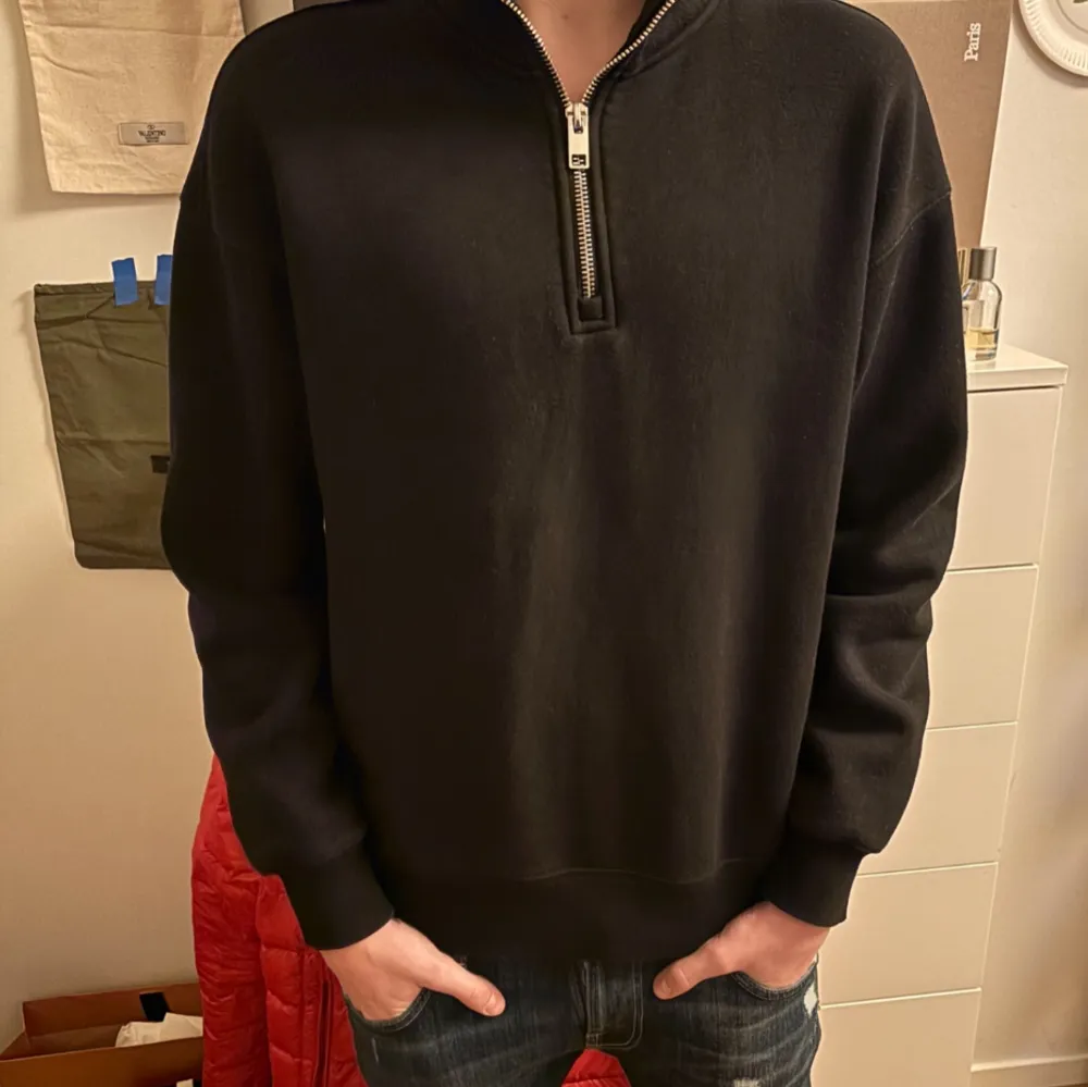 Säljer en stilren svart tröja med dragkedja i halsen. Tröjan har långa ärmar och en bekväm passform, perfekt för vardagsbruk. Passar bra till jeans eller chinos.. Neuletakit & Villapaidat.