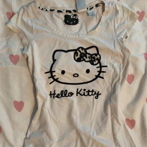 Hello Kitty t-shirt med leoparddetalj - Jättesöt Hello Kitty T-shirt med leopard detaljer. Tajt passform, passar storlek XS-S 🩷