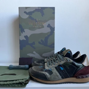 Valentino Rockrunner  Garavani sneakers i mocka och skinn - Snygga Valentino Garavani sneakers i en mix av mocka och skinn. Skorna har en unik färgkombination av grön, beige och vinröd med coola nitar på hälen. De kommer med extra skosnören och originalförpackning. Ny pris kostar de ungefär 8-9 tusen jag vill helst ha 1699 men kan diskuteras 
