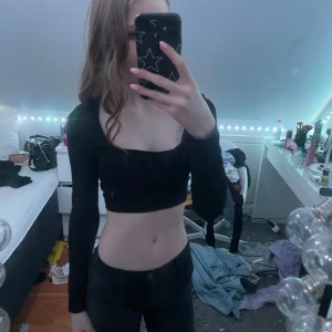 Svart croppad topp från Shein - Snygg svart croppad topp från Shein med långa ärmar och en smickrande passform. Perfekt för att skapa en stilren look. Toppen är tillverkad i ett mjukt och bekvämt material.