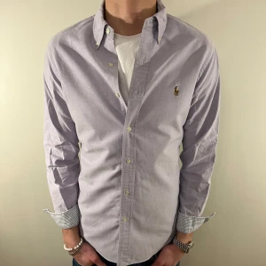 Ljuslila Ralph Lauren skjorta - Nu säljer vi ännu en fet polo skjorta som passar till alla tillställningar, skjortan är i mycket bra skick och är otroligt snygg med detaljerna i ärmarna och kragens insida! Du ska kunna utrycka din stil utan att det blir för dyrt!🕺🍾💼🤩  Storlek👔: M Nypris💰: ca 1499 kr