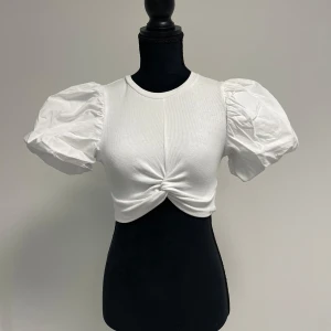 Vit topp - Kort topp med puffärmar och sydd knut från Zara. Använd endast ett fåtal gånger🌺