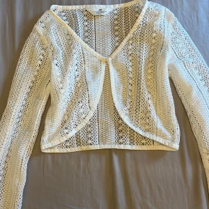 Vit tröja från H&M💗 - Säljer en söt vit tröja från H&M. Den har en v-ringad design och långa ärmar, perfekt för att ha på bikinin. 💗
