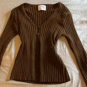 Brun ribbad kofta från Zara - Säljer en snygg brun ribbad kofta från Zara. Den har en v-ringad design med knappar framtill och långa ärmar. I stl 152 men jag skulle säga att den passar xs och s💗