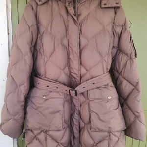 Burberry dunkappa - Burberry dunjacka i supermjuk och varm modell. Färgen är "nougat". Med avtagbar huva och bälte. Storlek XL. Mycket bra skick! Skickar gärna över fler bilder. 