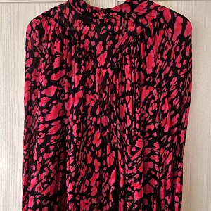 Svart och rosa mönstrad blus från InWear - Säljer en superfin blus med svart och rosa mönster från InWear, storlek 40. Den har en hög hals och knappar i nacken. Perfekt för både vardag och fest! 🖤💖