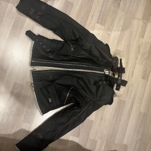 Svart skinnjacka från Jofama by Kenza - Säljer en snygg svart skinnjacka med fårpäls från Jofama by Kenza. Modellen heter B3 Flyer Leather Jacket. Jackan har aldrig använts och har inga skador.