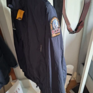 Parajumper windbreaker, storlek.S - Säljer en mörkblå windbreaker i storlek.S. passar dem som är runt 170-180. Den är I mycket bra sick och 100% äkta. Hör av er vid några frågor! 