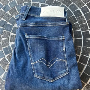 Blå jeans från Replay - Säljer ett par snygga blå jeans från Replay, modell Anbass. Jeansen är i bra skick har inga defekter, storlek 30/32. Skriv om ni har fler frågor!😄