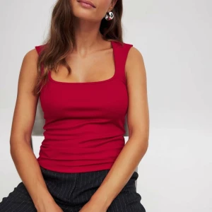 Röd topp - Snygg röd topp med fyrkantig halsringning. Endast använd 1 gång så därav i väldigt bra skick