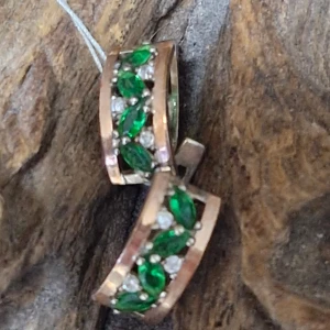 Örhängen med gröna och vita stenar - Snygga örhängen i guldton med glittrande gröna och vita stenar. De har en elegant design med en rad av gröna, bladformade stenar omgivna av små vita stenar. Perfekta för att ge en färgklick till din outfit!