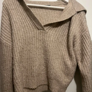 Beige stickad tröja från Gina Tricot - Mysig beige stickad tröja från Gina Tricot i storlej S. Tröjan har en avslappnad passform och en snygg krage som ger en extra touch. Använd en del, men ändå bra skick!🤍 Något noppig, men inga större defekter.