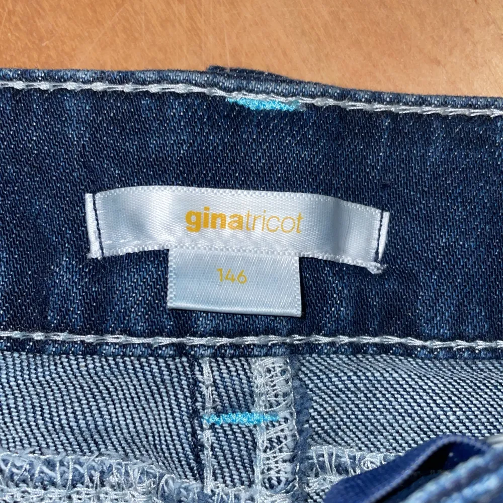 Säljer ett par snygga mörkblå bootcut jeans från Gina Tricot i storlek 146 i tall . De har knappfickor bak. De ljusa sömmar och går att spänna i midjan.. Jeans & Byxor.