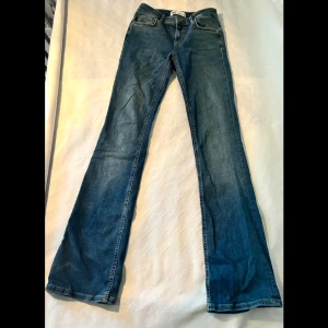 Blå jeans från Zara, bootcut low waist - Säljer ett par snygga blå jeans från Zara i storlek 34. De har en klassisk bootcut-stil och low waist och är i nyskick (aldrig använda).