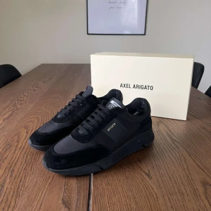 Svarta sneakers från Axel Arigato - Säljer ett par stilrena svarta sneakers från Axel Arigato i nytt skick. Skorna har en snygg kombination av mocka och syntetmaterial med klassisk snörning. Kommer i originalkartong. Nypris: 2500kr. Hör av dig vid fler frågor!