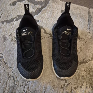 Svarta Nike sneakers - Säljer ett par svarta Nike sneakers i mycket bra skick. De har en stilren design med vit sula och Nike-logga på sidan. Perfekta för både vardag och träning. Skorna har en bekväm passform och är lätta att matcha med olika outfits.