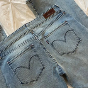 Ljusblå jeans från Levi's - Säljer ett par klassiska ljusblå Levi's jeans i bra skick. De har en bootcut passform och är lågmidjade med fem fickor och knappgylf.💫midjemått 36cm