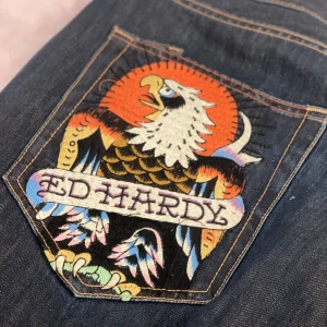 Ed Hardy jeans med broderad örn - Säljer ett par ascoola baggy Ed Hardy jeans! Dem är eltejpade upp i benen (kan skicka bild) då dem är alldeles för långa för mig (165)❤️Har lite små fläckar/missfärgningar❤️