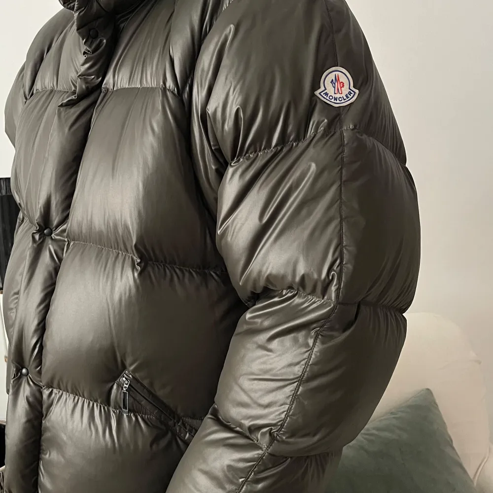 Säljer en snygg och varm grå dunjacka från Moncler. Jackan har en pufferstil med långa ärmar och dragkedja. Perfekt för kalla vinterdagar. Den är i mycket bra skick och redo för nya äventyr. Passar perfekt för vinterns alla aktiviteter! 🖤. Jackor.