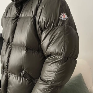Moncler dunjacka vintage 90-tal - Säljer en snygg och varm grå dunjacka från Moncler. Jackan har en pufferstil med långa ärmar och dragkedja. Perfekt för kalla vinterdagar. Den är i mycket bra skick och redo för nya äventyr. Passar perfekt för vinterns alla aktiviteter! 🖤