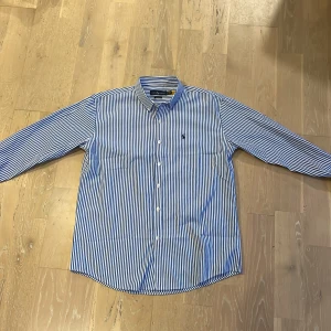 Randig Ralph Lauren skjorta - Blå och vit randig skjorta från Ralph Lauren i storlek herr M/L. Den är alldeles för stor på mig och skulle säga att den sitter som en L. Den är endast testad 1-2 gånger därav så gott som ny. Skriv gärna om du har några frågor!