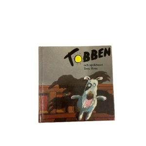 Tobben och spökhuset - En spännande barnbok om Tobben och hans äventyr i ett spökhus. Boken har en färgglad och lekfull framsida med en tecknad hund i fokus. Perfekt för barn som gillar mysterier och äventyr!