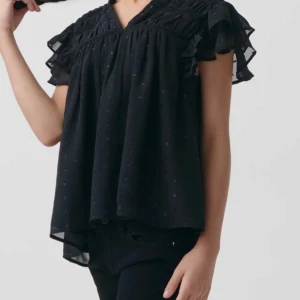 Svart blus med volangdetaljer - Snygg svart blus med volangdetaljer och korta ärmar. Perfekt för en stilren look. Blusen har en lätt v-ringning och ett diskret mönster som ger en extra touch. Helt oanvänd lappen är fortfarande kvar