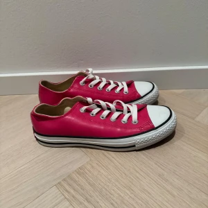 Rosa sneakers från Converse - Snygga rosa, glansiga Converse sneakers med klassisk vit sula och snörning. Perfekta för en avslappnad stil. De har den ikoniska All Star-loggan på hälen.