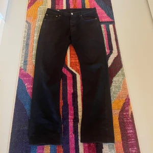 Svarta Levis 501  - Säljer ett par klassiska svarta Levis 501 jeans. De har en rak passform och är storlek 32/32. Blivit lite solblekta men syns bara i starkt ljus. För fler frågor eller bilder är det bara att kontakta mig😊