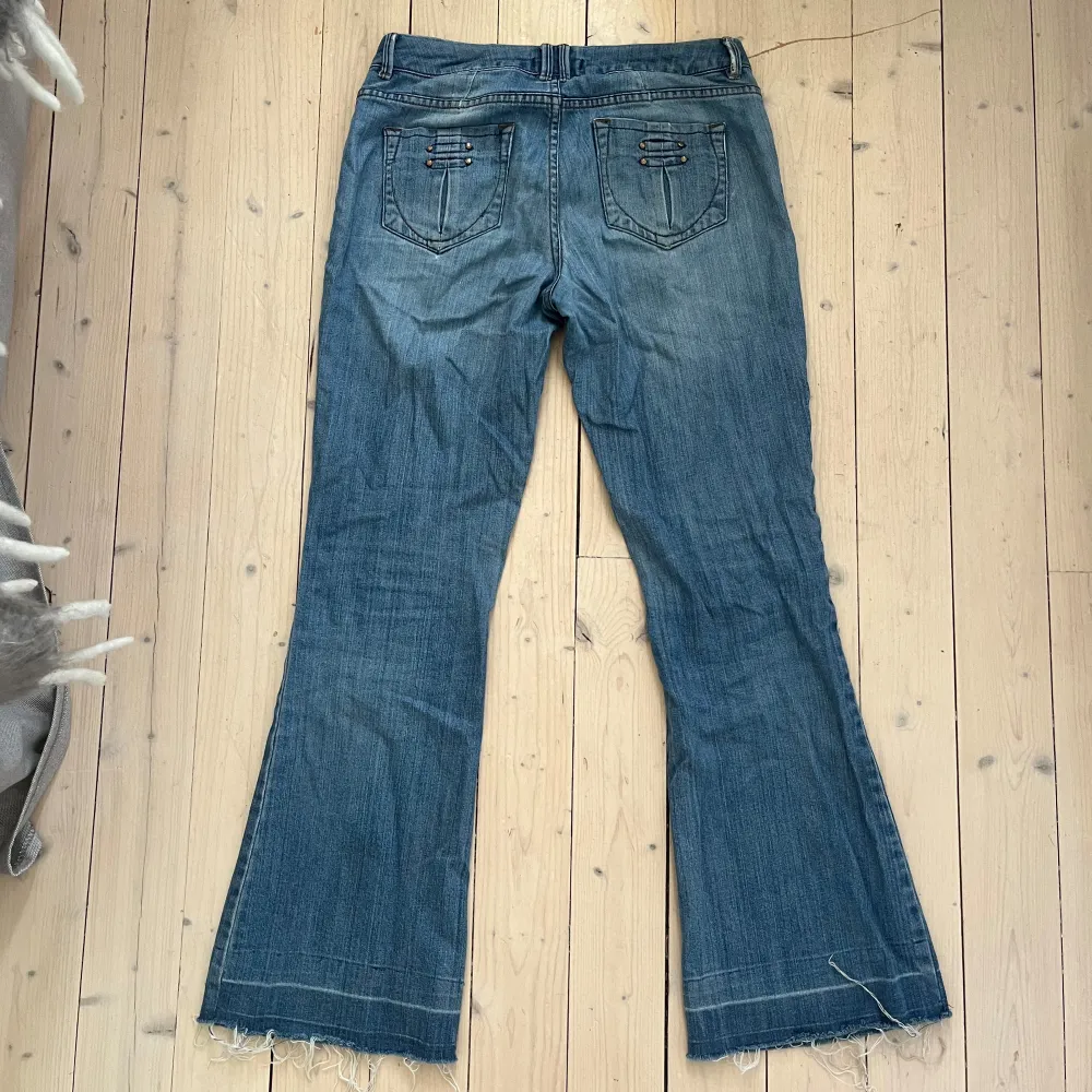 Säljer ett par snygga blå jeans från Promod. De har en bootcut-stil och är i bra skick. Midjemått: 40cm Innerbenslängd: 73cm. Jeans & Byxor.