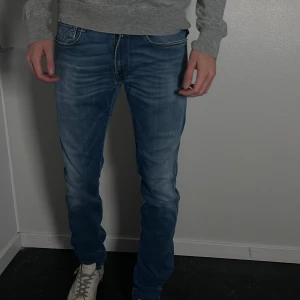 Anbass jeans - Jeans i modellen hyperflex, från replay. Har en liten slitning på övre låret, syns på bilden - ska vara i designen. Innerbenslängd: 90cm midjemått: 42cm