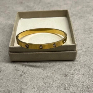 Guld armband  - Guld armband med stenar i rostfritt stål. Aldrig använd